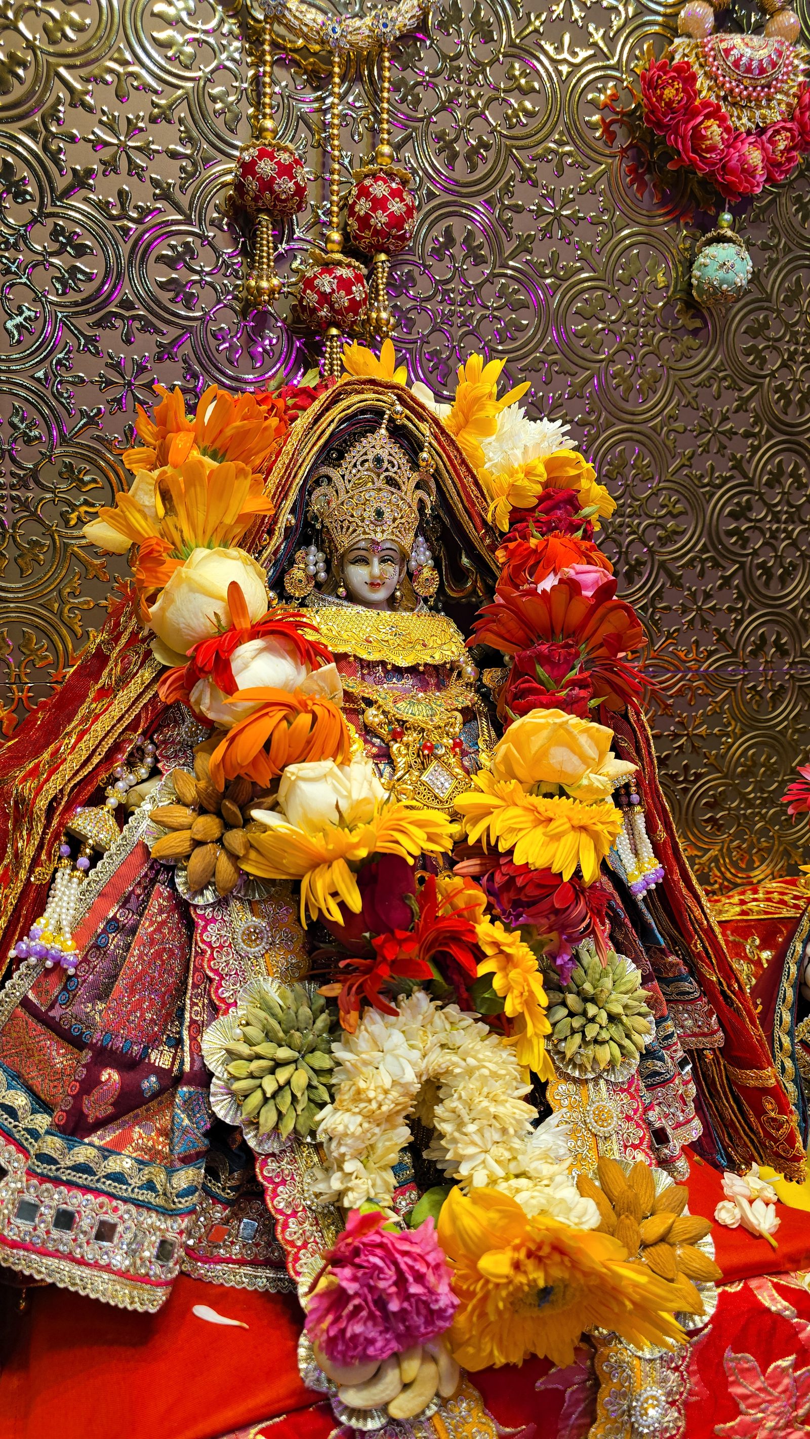 Shri Bhagwati Devi adorned in flowers and gold at the shrine